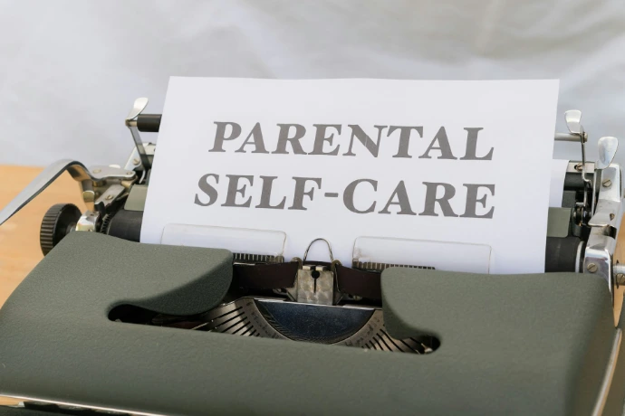 a typewriter with a paper that reads parental self - care